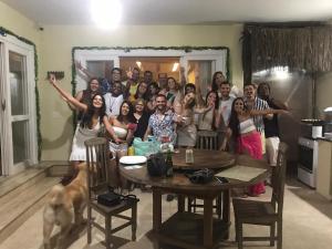 un grupo de personas de pie en una cocina con un perro en Sam's Home, en Río de Janeiro