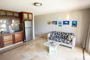 a living room with a couch and a refrigerator at Seaside Apartment Pelican in Kralendijk