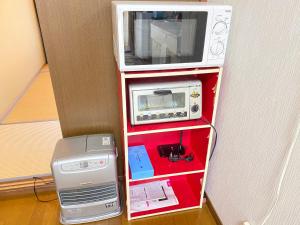 a shelf with a microwave and a printer on it at kASUMI-an4 in Kumamoto