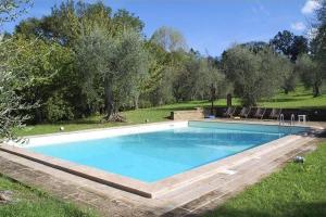 a large swimming pool in a field with trees at Villa Podere Torre in San Gervasio