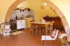 eine Küche mit einem Tisch und Stühlen im Zimmer in der Unterkunft Villa Podere Torre in San Gervasio