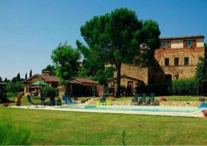 uma casa com um quintal com cadeiras e uma piscina em La Villa em Lucignano