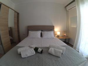 a bedroom with a bed with two bottles and towels at Chrysafenia & Leandros Downtown in Kavála