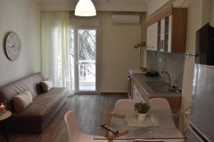 a kitchen and living room with a couch and a table at Chrysafenia & Leandros Downtown in Kavála
