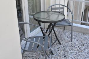 a glass table and a chair on a balcony at Chrysafenia & Leandros Downtown in Kavála