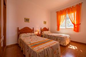 a bedroom with two beds and a window at Chalet Pedro II in Conil de la Frontera
