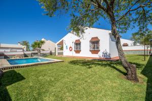 a house with a swimming pool and a yard at Chalet Pedro II in Conil de la Frontera