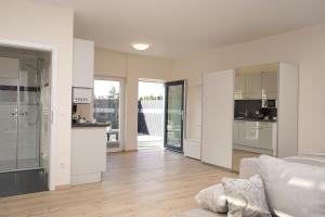 a kitchen and living room with white walls and wooden floors at BestBoarding24 in Sulzbach am Main