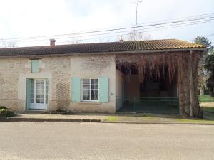 ein Backsteinhaus mit grünem Tor davor in der Unterkunft La Maison des cressonnières in Saint-Pardoux-du-Breuil