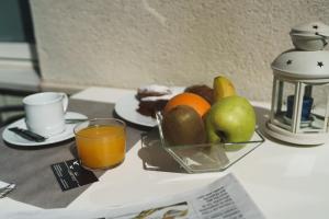 a table with a bowl of fruit and a cup of orange juice at Hotel Albatros in Gandía