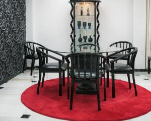 a dining room table with black chairs and a red rug at Hotel Albatros in Gandía