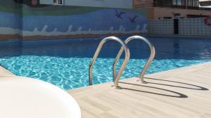 a swimming pool with two metal bars in the water at Hotel Albatros in Gandía