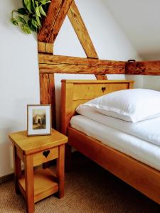 a bedroom with a bed and a table with a picture at Casa Dávid Ferenc Ház in Deva