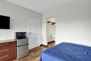 a bedroom with a bed and a tv on a counter at Zen Living Suites Extended Stay - Jacksonville - Orange Park in Orange Park