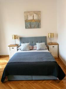 ein Schlafzimmer mit einem blauen Bett und zwei Nachttischen in der Unterkunft Apartament Basia in Hajnówka