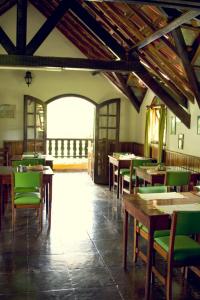 a dining room with tables and green chairs at Pousada Sonho Verde in Monte Verde