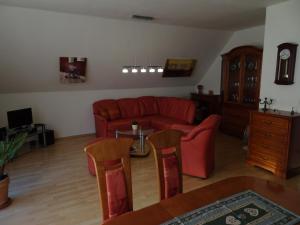 ein Wohnzimmer mit einem roten Sofa und einem Tisch in der Unterkunft Helle moderne 52 qm Wohnung mit Balkon in Chemnitz