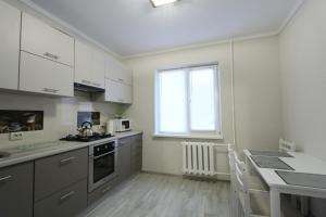 een keuken met witte kasten en een tafel en een raam bij Вернадського 4 CityRooms in Bila Tserkva