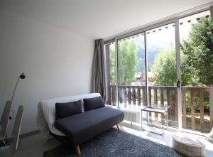 - un salon avec une chaise et une grande fenêtre dans l'établissement Studio lumineux avec vue sur le massif du Mont-Blanc, à Chamonix-Mont-Blanc