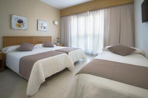 a hotel room with two beds and a window at Hotel Albatros in Gandía