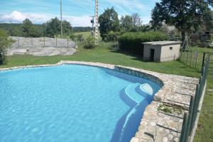 a swimming pool in a yard with a retaining wall at Masoveria la Roca in Sagás