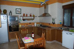 a kitchen with a table with a bottle of wine on it at CASA RURAL RIO CABRIEL in Villamalea