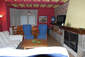 a living room with blue chairs and a fireplace at CASA RURAL RIO CABRIEL in Villamalea