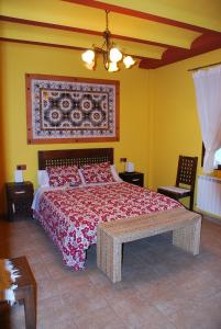 1 dormitorio con 1 cama grande con colcha roja en CASA RURAL RIO CABRIEL en Villamalea