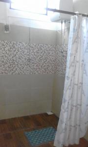 y baño con ducha y cortina de ducha. en POSADA, en Minas