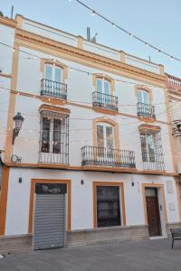 a white building with windows and balconies at Apartamentos La Bola Suite in Ronda
