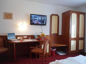 a hotel room with a desk with a laptop on it at Hotel Hutzenthaler in Bruckberg