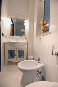 Łazienka z białą toaletą i umywalką w obiekcie LA DIMORA DI MINERVA w mieście Minervino Murge
