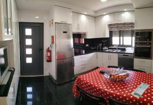 uma cozinha com uma mesa com uma toalha de mesa de bolinhas vermelhas em Peter Love House em Ericeira