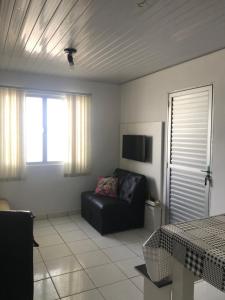 uma sala de estar com um sofá e uma janela em Casa praia frente ao mar em Florianópolis