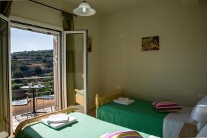 a room with two beds and a balcony with a view at Villa Katerina (Michalis) in Séllai