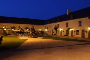 a large building with a courtyard at night at Domaine Utah Beach - Le Grand Hard in Sainte-Marie-du-Mont