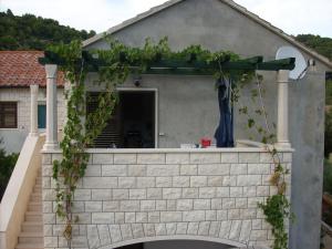 un mur en briques recouvert de lierre devant une maison dans l'établissement Apartments DARIJA & PERO, à Pučišća
