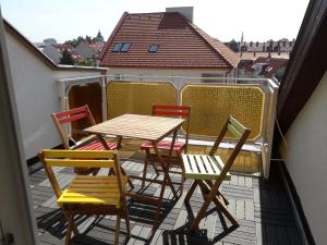 einen Tisch und 4 Stühle auf einem Balkon in der Unterkunft 8x8 Tetőtér Apartman in Szeged