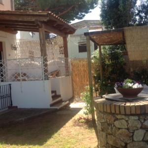 einen Garten mit einer Steinmauer und einem Pavillon in der Unterkunft Villino Lory in Sperlonga