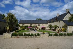 a large stone building with purple umbrellas at Domaine Utah Beach - Le Grand Hard in Sainte-Marie-du-Mont