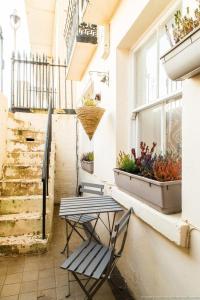 a bench sitting next to a window with plants at Seafront Apartment with Garden in Brighton & Hove