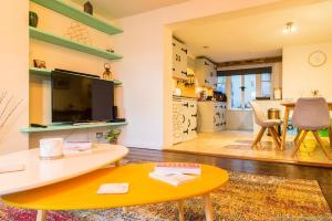 a living room with a table and a tv at Seafront Apartment with Garden in Brighton & Hove