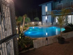 una piscina en un patio por la noche en Villa Joel, en Fontane Bianche