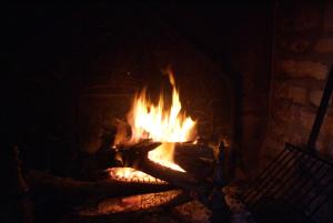 a fire in a brick fireplace with flames at Domaine Utah Beach - Le Grand Hard in Sainte-Marie-du-Mont