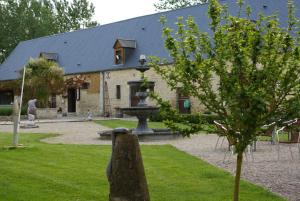 a building with a fountain in front of a yard at Domaine Utah Beach - Le Grand Hard in Sainte-Marie-du-Mont