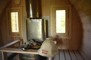 a stove in a wooden cabin with two windows at Sämi Siil in Sämi