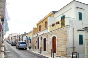 una calle con edificios y coches estacionados en la calle en LA DIMORA DI MINERVA, en Minervino Murge