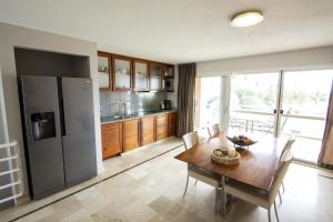 eine Küche mit einem Holztisch und einem Kühlschrank in der Unterkunft Seaside Apartment Turtle in Kralendijk