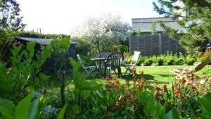 ogród ze stołem, krzesłami i kwiatami w obiekcie GIVERNY COTTAGE w mieście Saint-Coulomb