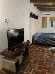 a bedroom with a flat screen tv and a bed at La Maison De Valerie in Punta Del Diablo